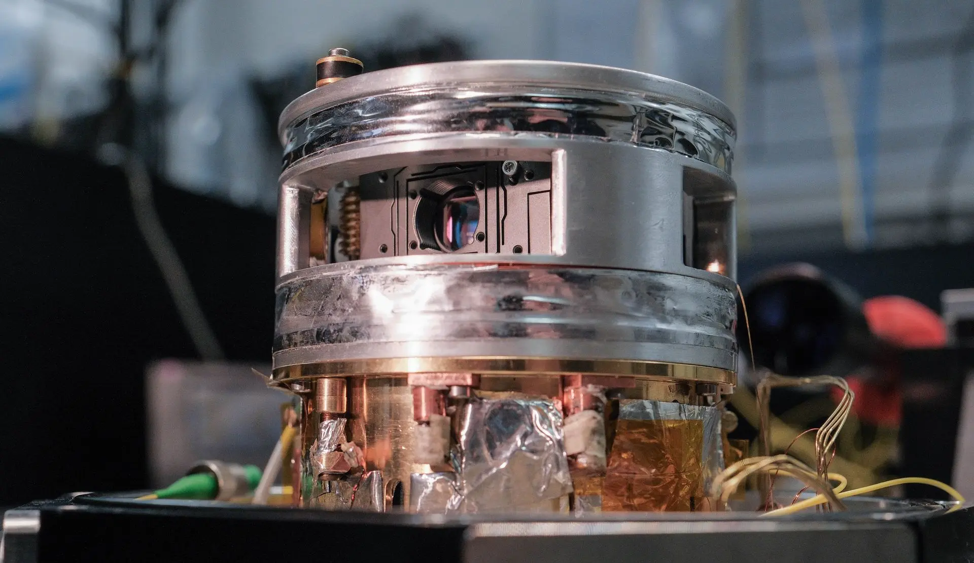 Magnetic-field-integrated microcavity platform featuring Helmholtz coils for perpendicular field application and magneto-optical or spin control experiments.
